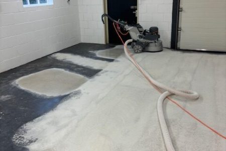 Betonvloer schuren waarbij oude coating machinaal wordt verwijderd met stofafzuiging